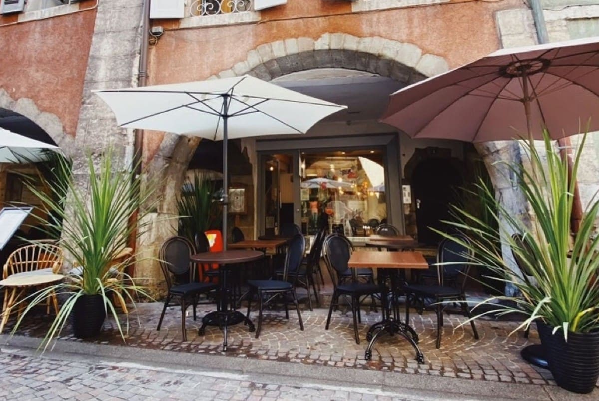Le Bar Roux d'Heure storefront and terrace under the arcades of Rue Filaterie, Annecy